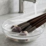 Luxury makeup brushes stored upright inside a clear acrylic organizer